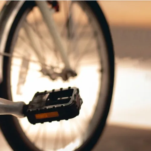 Polkupy&ouml;r&auml;, l&auml;hell&auml; oleva poljin ja taustalla auringonlasku.