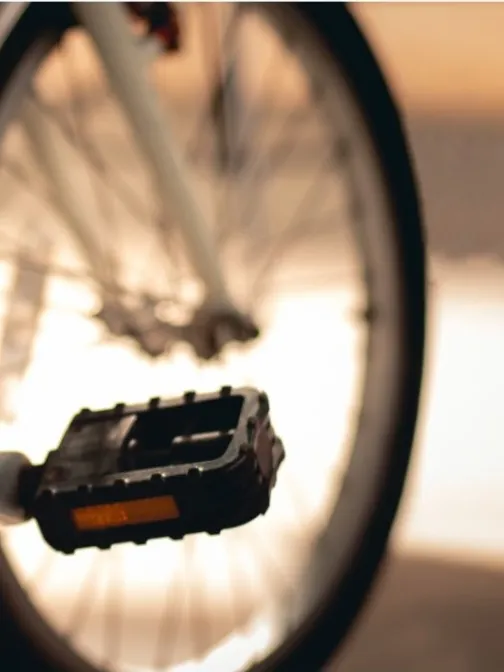 Polkupy&ouml;r&auml;, l&auml;hell&auml; oleva poljin ja taustalla auringonlasku.