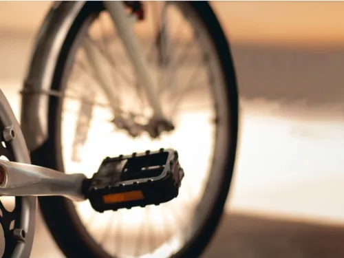 Polkupy&ouml;r&auml;, l&auml;hell&auml; oleva poljin ja taustalla auringonlasku.